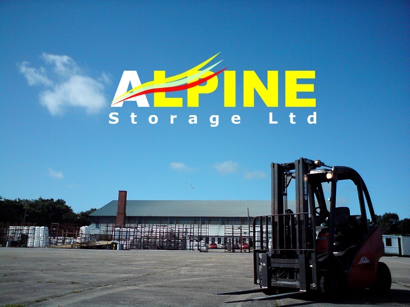 Forklift truck in the foreground on a runway with a warehose in the background