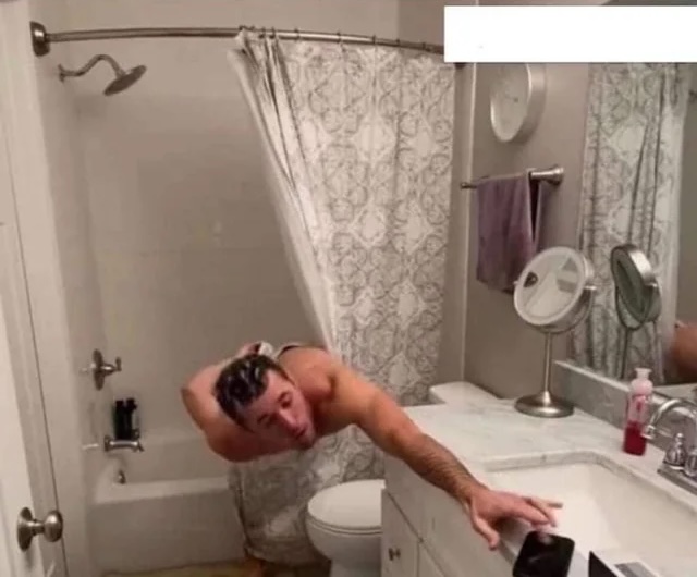 Man leaning out of bath to change radio channel