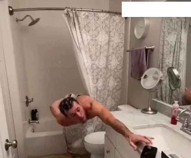 Man leaning out of bath to change radio channel