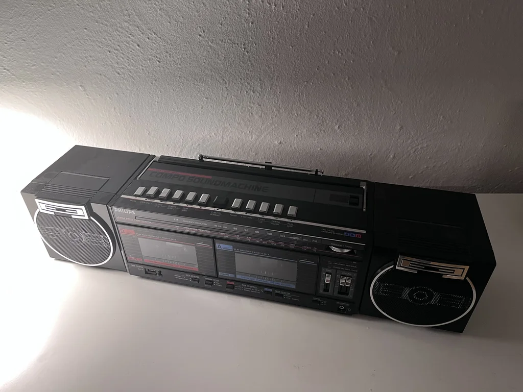 Black boombox with silver trim, two tape decks, two speakers and a radio antenna