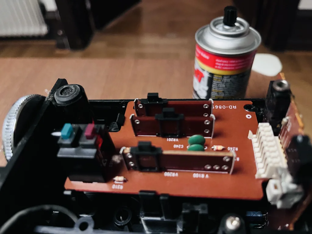 Brown circuit board with some sliding adjustable potentiometers. In the background the DeoxitD5 spray is visible.